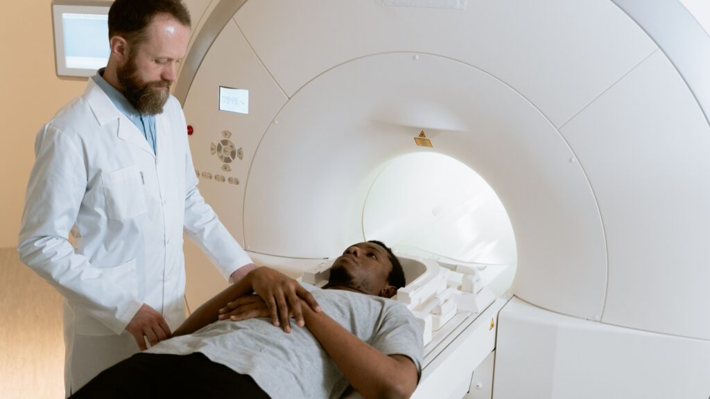 A technologist positioning a patient on the table of an MRI scanner