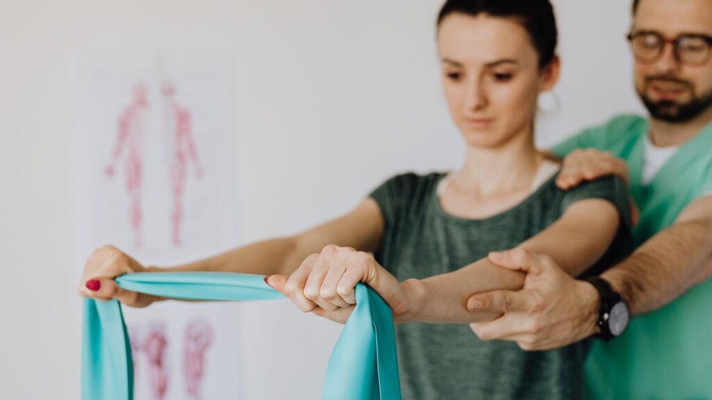 A therapist guiding a patient through a resistance band exercise