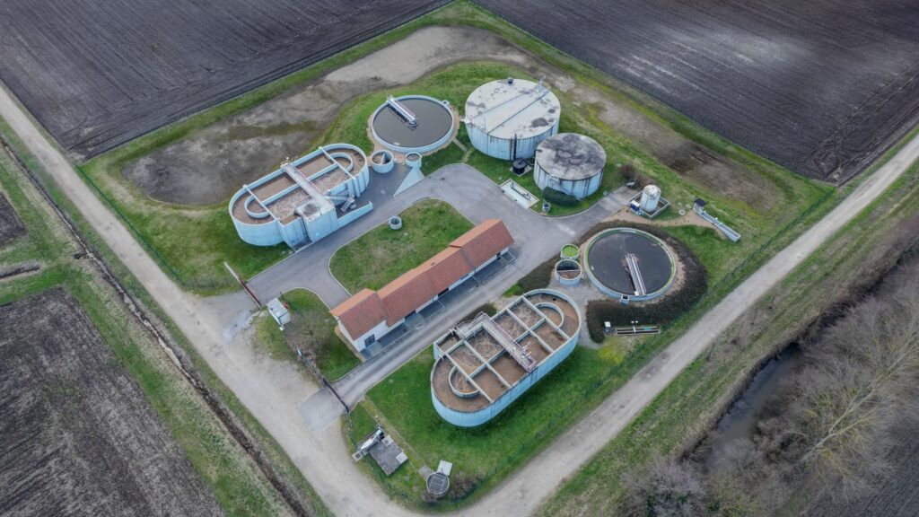 An aerial view of the circular clarifiers and filter beds of a wastewater treatment works